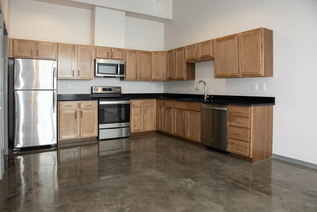 an empty kitchen with wooden cabinets and stainless steel appliances