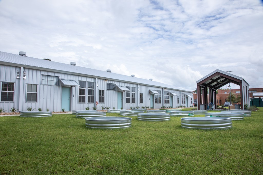 the exterior of a building with a row of hoops on the grass