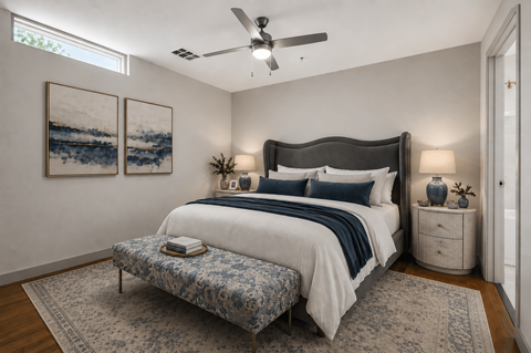 A bedroom with a large bed and a ceiling fan.