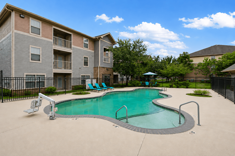 A swimming pool in front of apartment buildings.