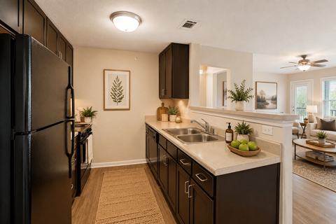A kitchen with a black fridge and brown cabinets.