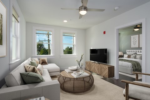 A living room with a white couch and a television.