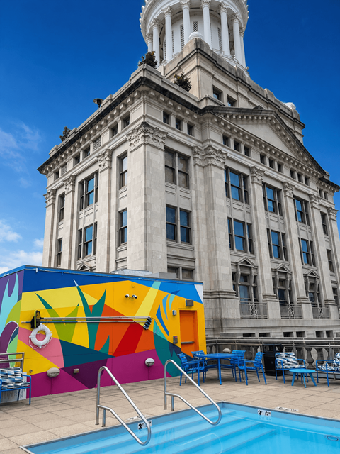 A pool with a colorful mural on the side of a building.