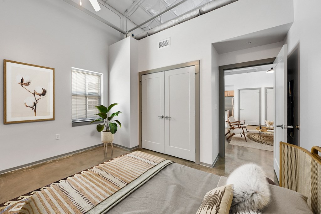 a living room with a couch and a rug and a door to a hallway