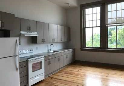 A kitchen with wooden floors and white appliances.
