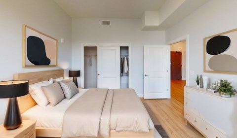 A bedroom with a large bed and two nightstands.