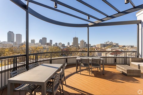 A patio with a table and chairs overlooking a city skyline.