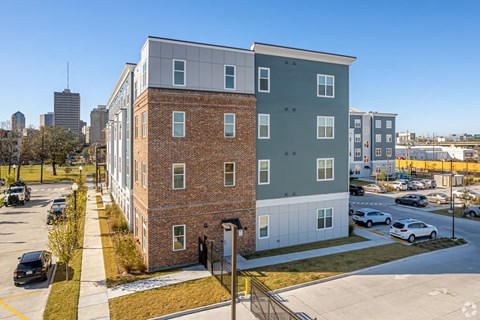 A modern apartment building with a parking lot in front.
