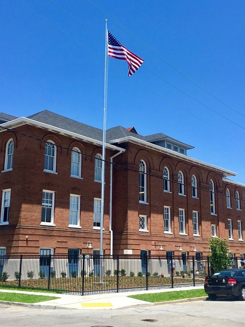 A red brick building with an American flag on top.