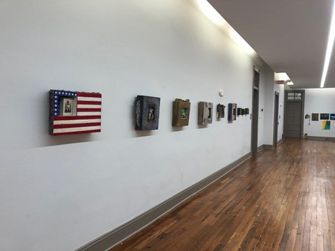 A hallway with a flag and pictures on the wall.