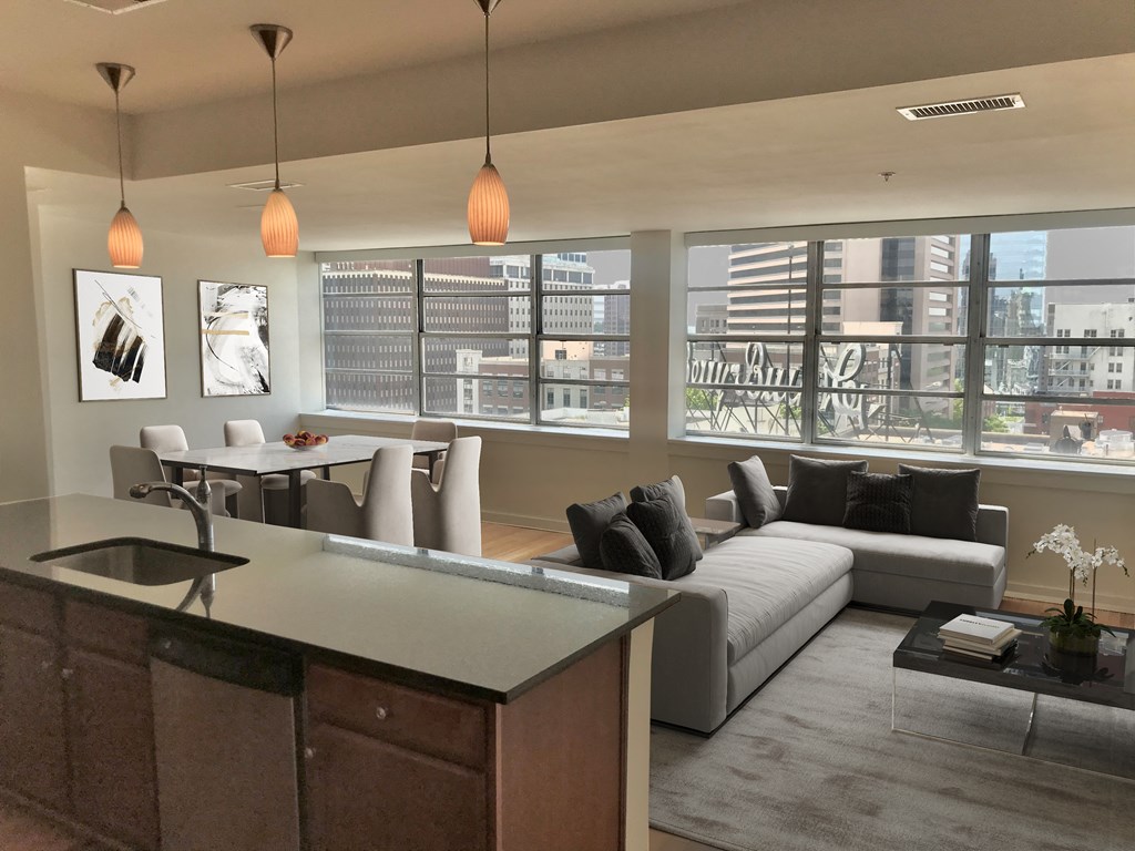 a living room with a white couch and a table and some windows