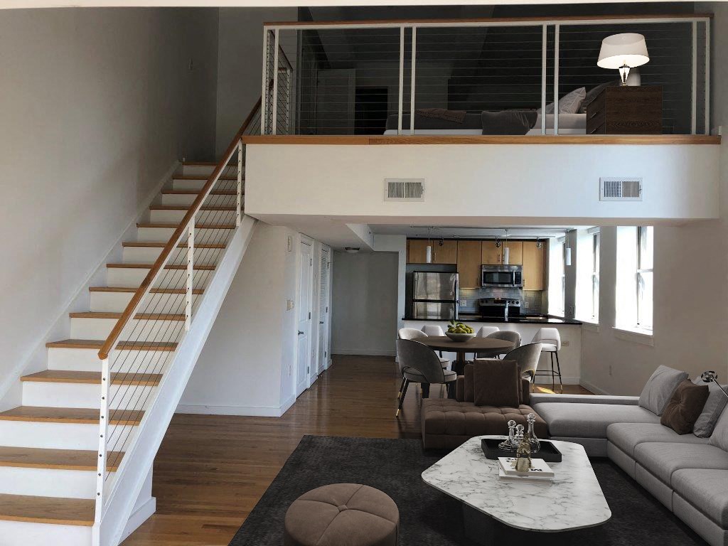 a living room with a staircase and a dining room