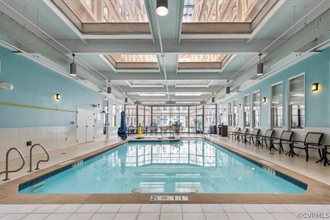 A large indoor swimming pool with a glass ceiling.