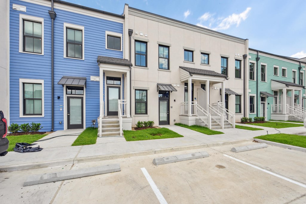A row of townhouses with blue and beige exteriors.