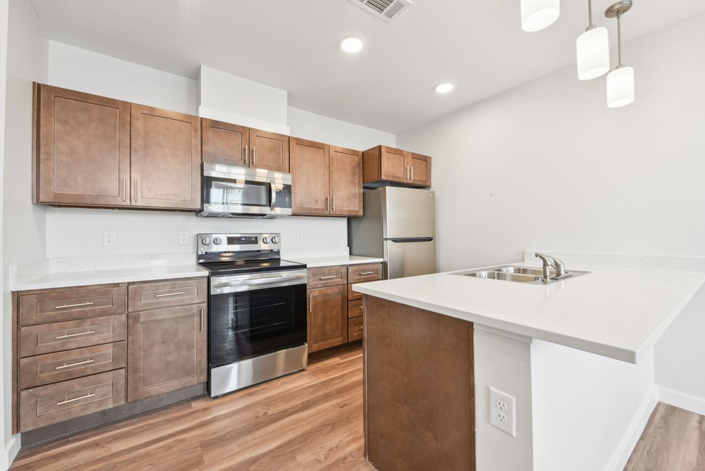 A modern kitchen with wooden cabinets and stainless steel appliances.
