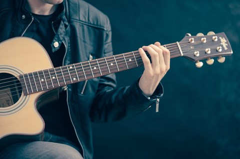 a person playing a guitar on a black background