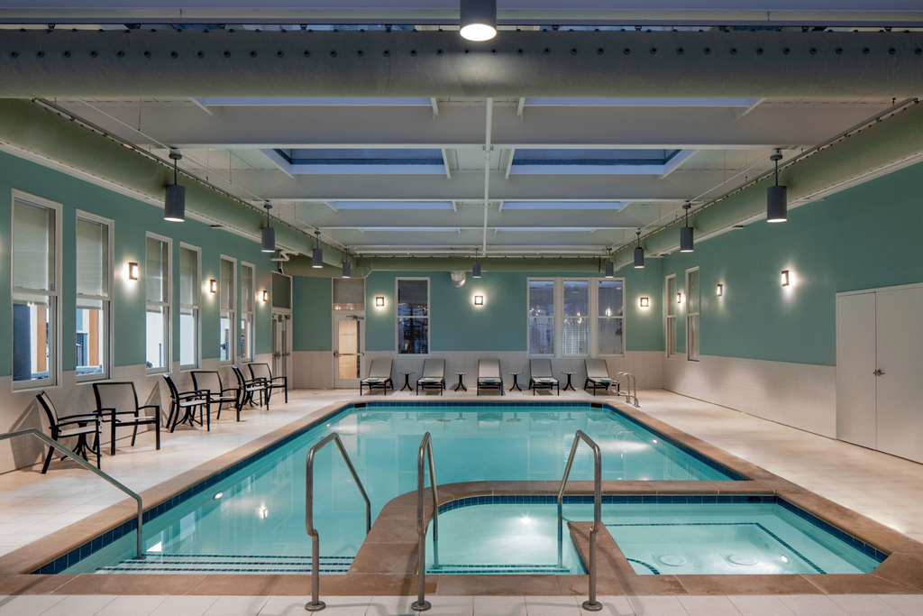 a swimming pool in a room with chairs