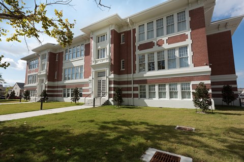 A red and white building with a green lawn in front.
