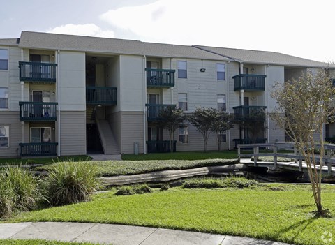 Apartment complex with a small tree in front.