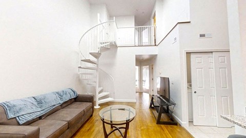a living room with a couch and a spiral staircase