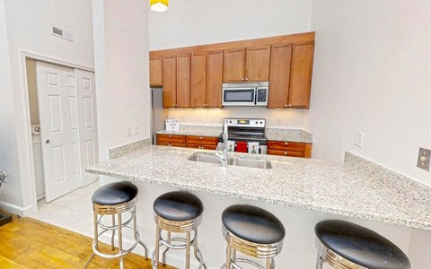 a kitchen with a counter with four bar stools