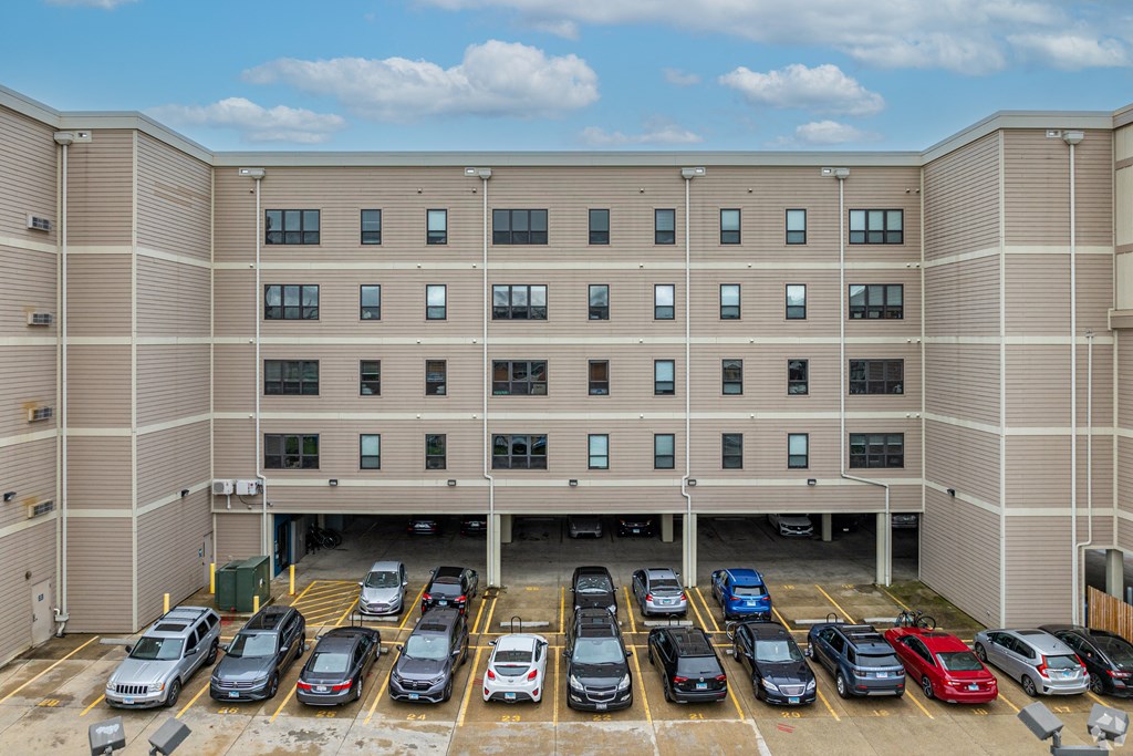 an apartment building with a parking lot full of cars