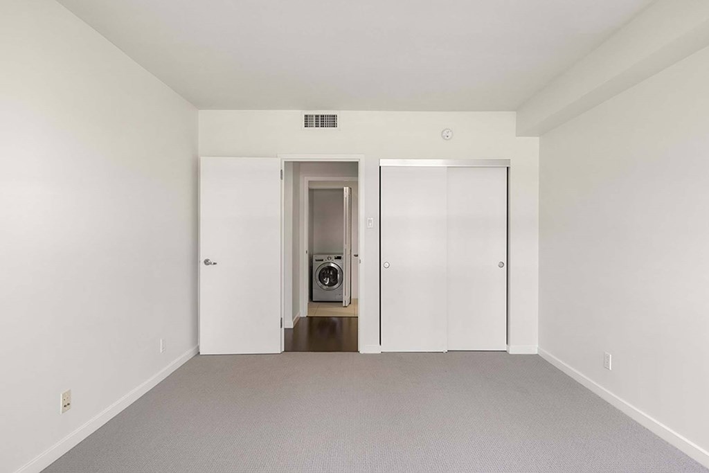 A white room with a washer and dryer in the doorway.