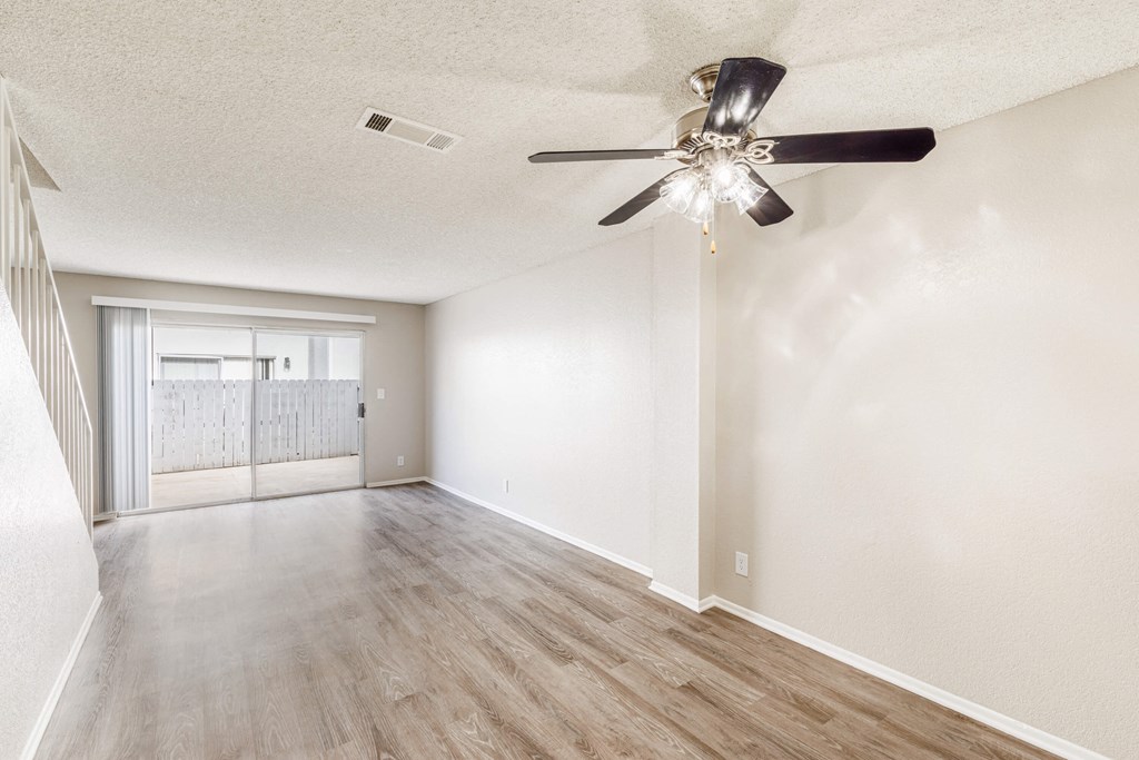 the spacious living room and dining room with a ceiling fan
