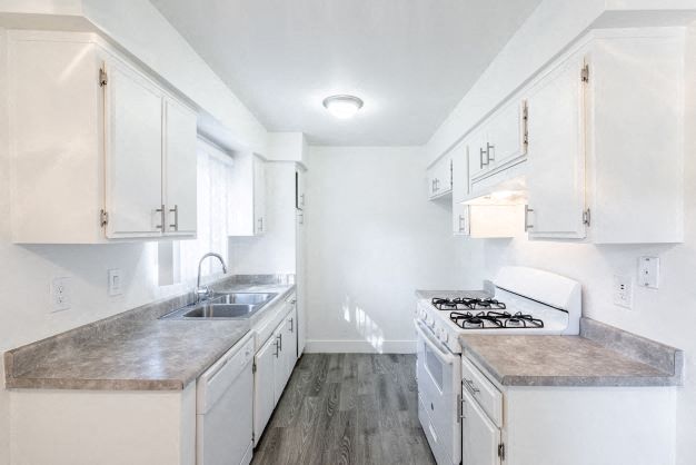 a kitchen with white cabinets and a stove and a sink