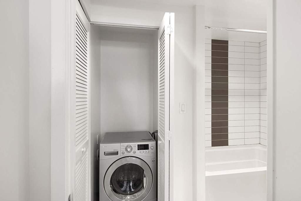 A washing machine is placed in a small laundry room.