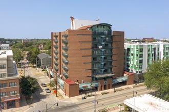 an aerial view of a brick building with a green and white building next to it