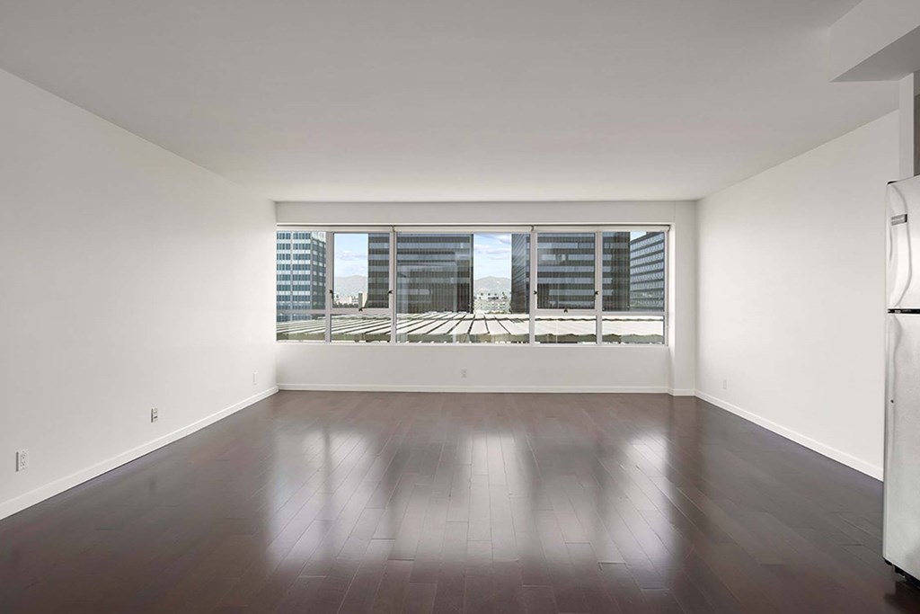 A room with a large window and wooden flooring.
