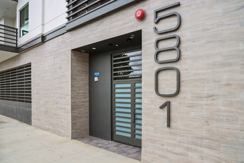 a view of the entrance to the building with the number 5690 on the side at The Fairfax Flats Apartments, Los Angeles, CA