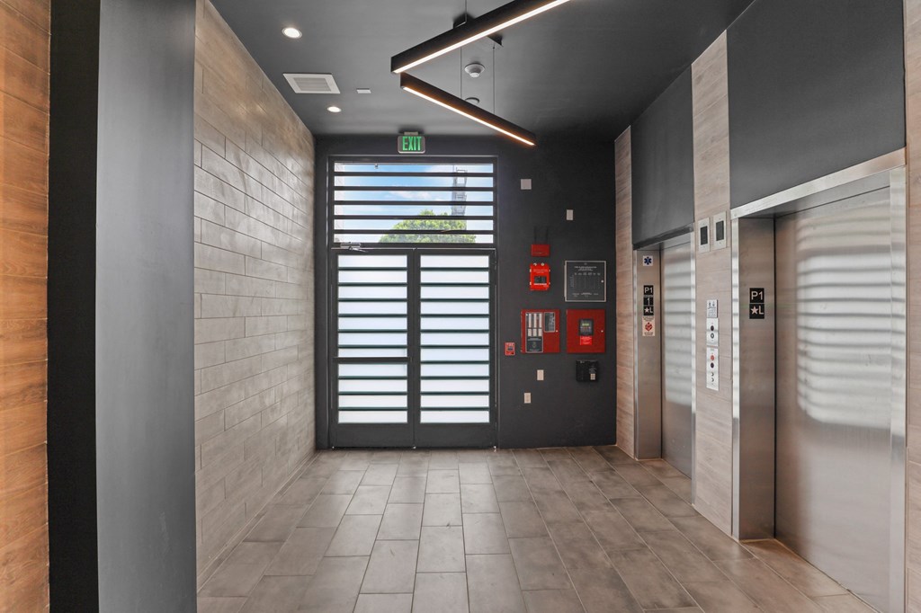 a view of a hallway with a door at the end of the hallway at The Fairfax Flats Apartments, Los Angeles, CA, 90019