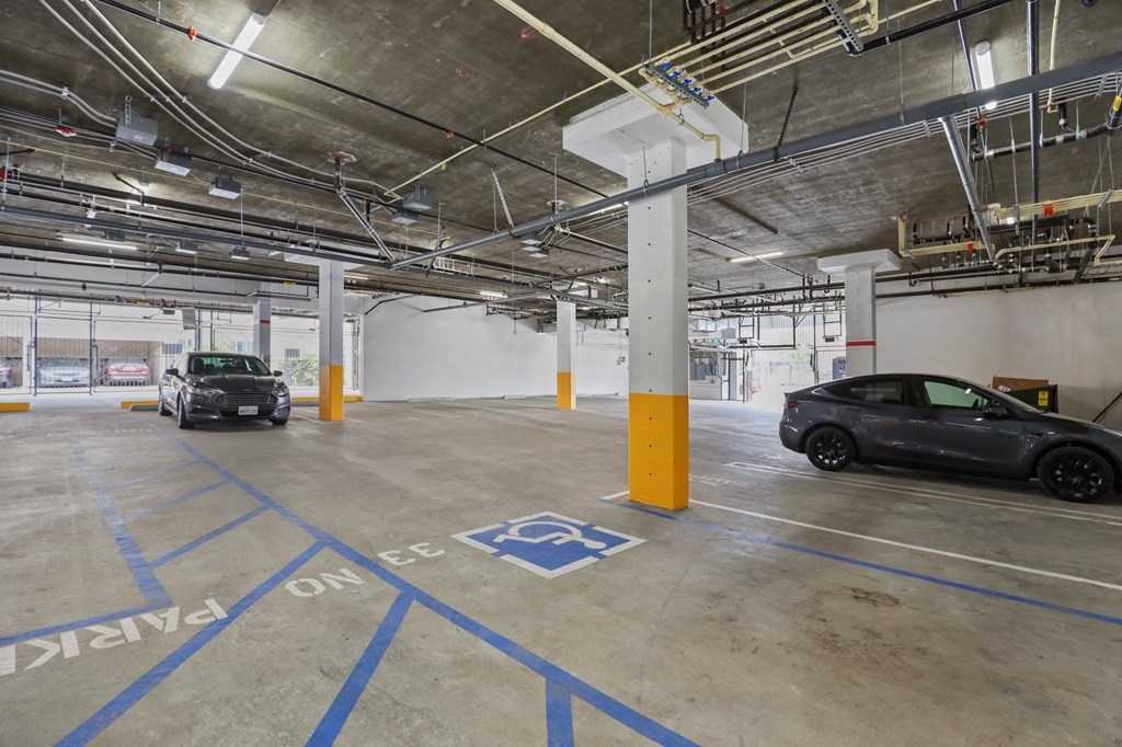 a parking garage with two cars in it at The Fairfax Flats Apartments, Los Angeles, California