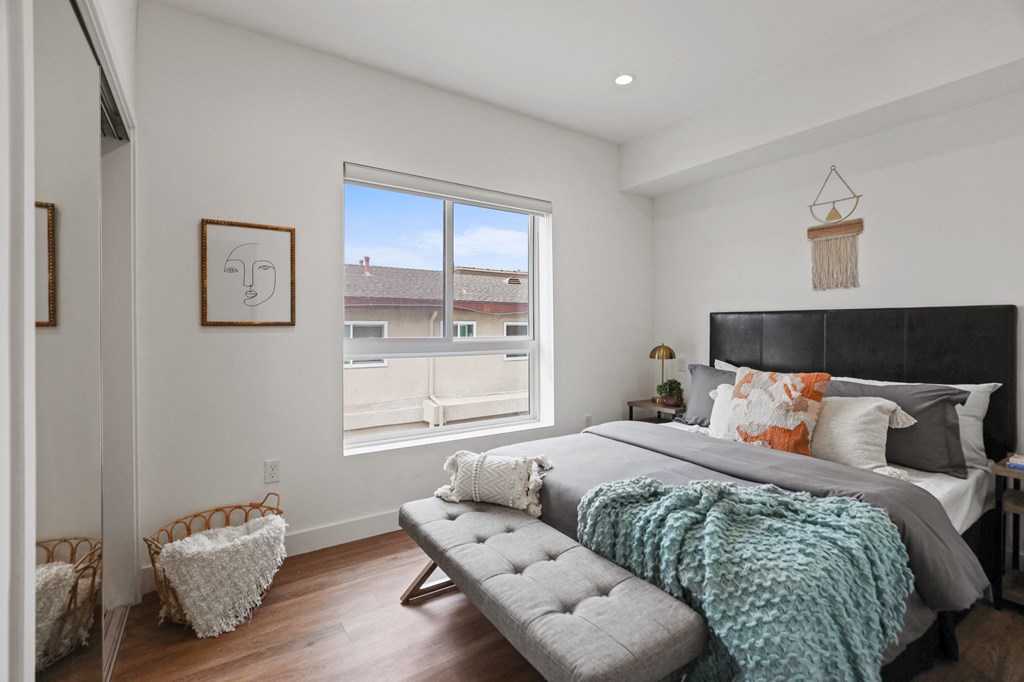 a bedroom with a large bed and a large window at The Fairfax Flats Apartments, Los Angeles, CA