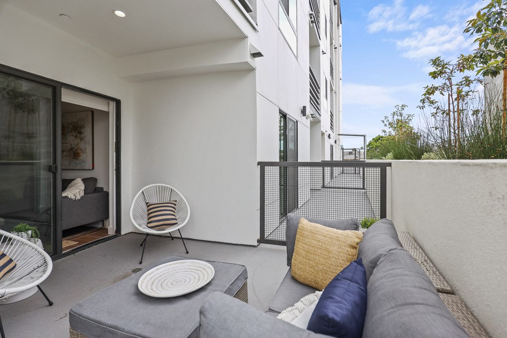 two chairs and a couch on a balcony in a 555 waverly unit at The Fairfax Flats Apartments, Los Angeles, CA