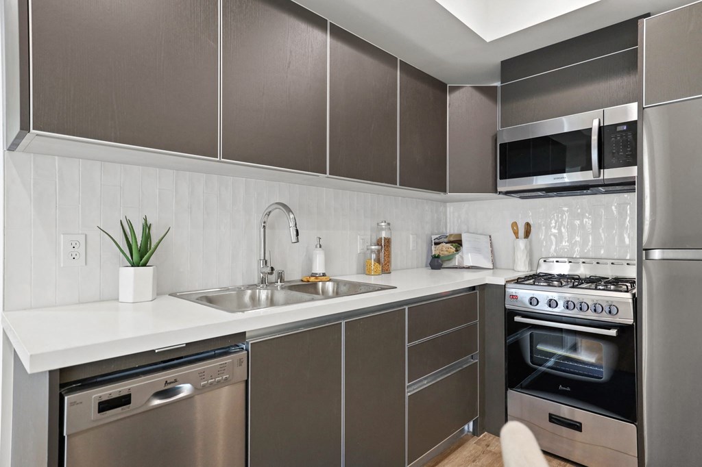 a kitchen with grey cabinets and a white counter top at The Fairfax Flats Apartments, Los Angeles, CA, 90019
