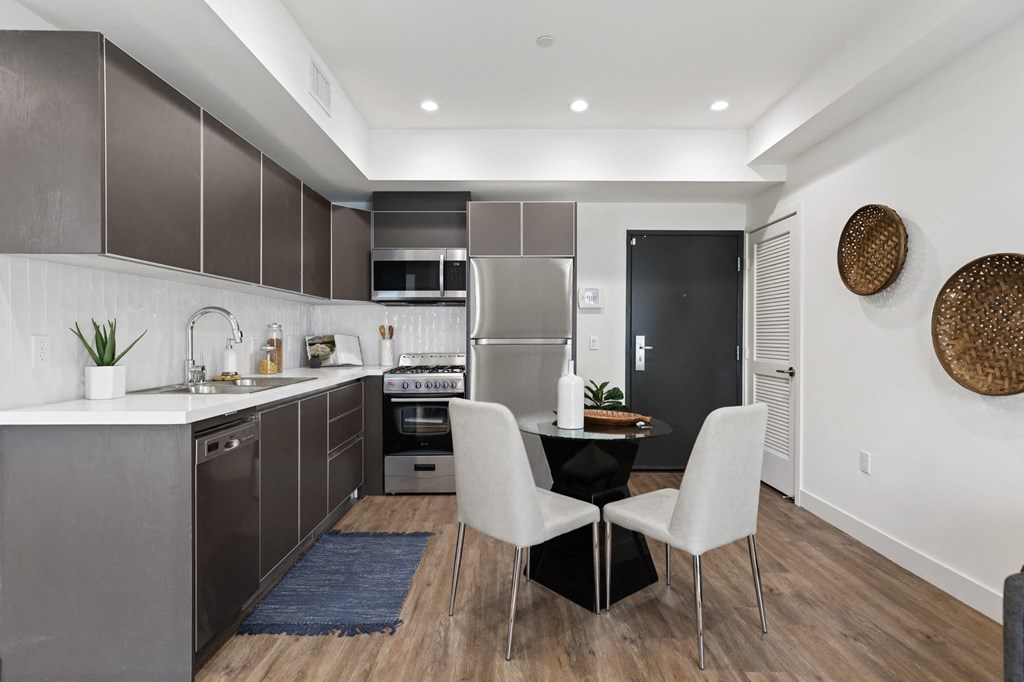 a kitchen with dark cabinetry and white countertops at The Fairfax Flats Apartments, Los Angeles, CA