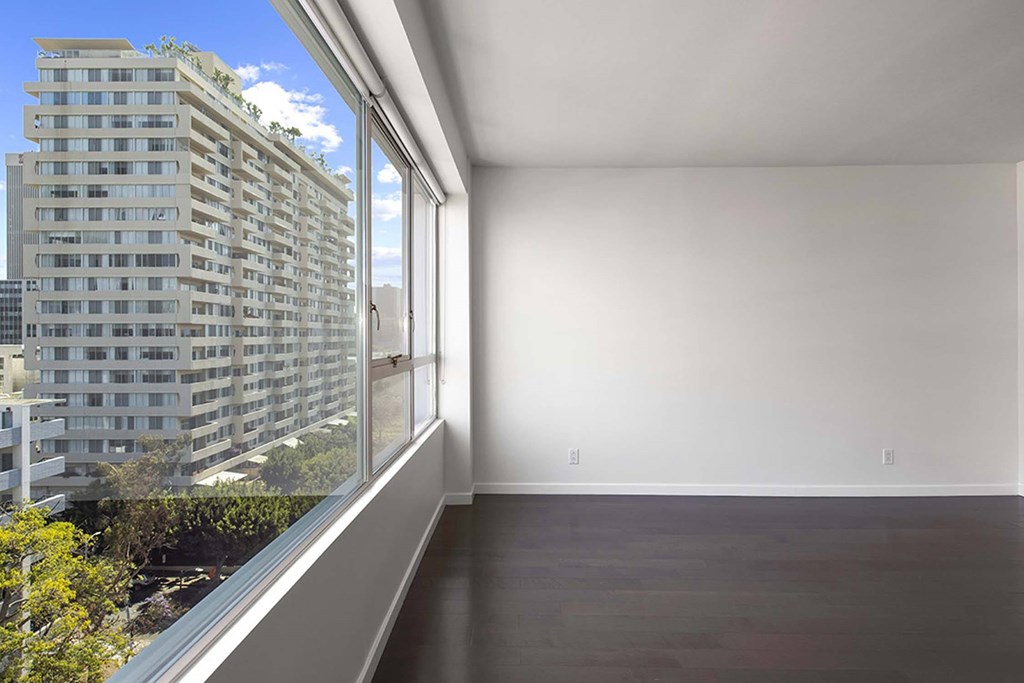A room with a large window overlooking a cityscape.