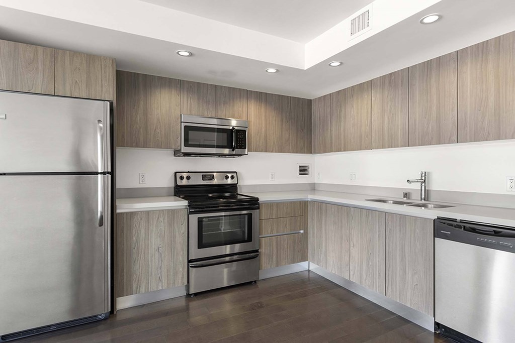 A modern kitchen with stainless steel appliances and wooden cabinets.