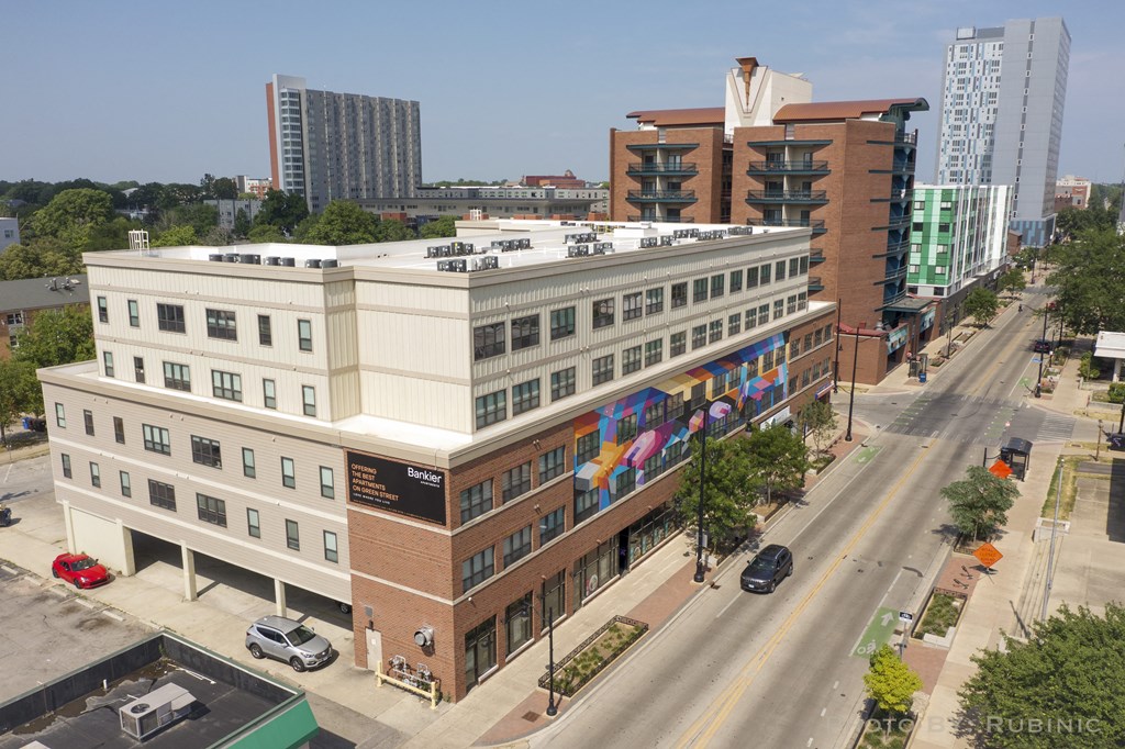 an aerial view of a brick and white building with a colorful mural on the side of it