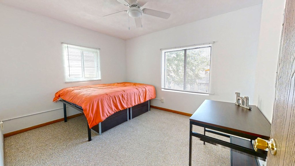 a bedroom with a bed and a desk