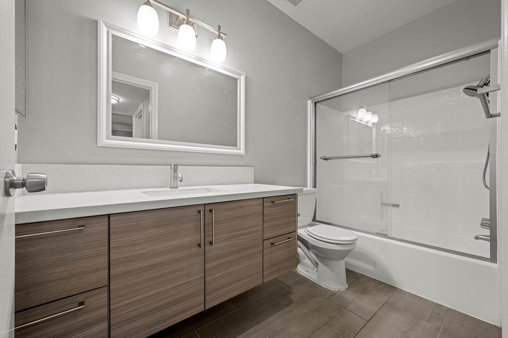 A modern bathroom with a white sink and a large mirror at Lafayette Apartments, Los Angeles