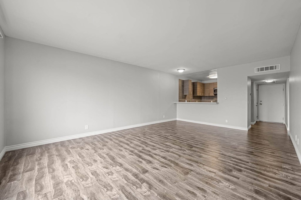 A room with wooden flooring and white walls at Lafayette Apartments, Los Angeles, California