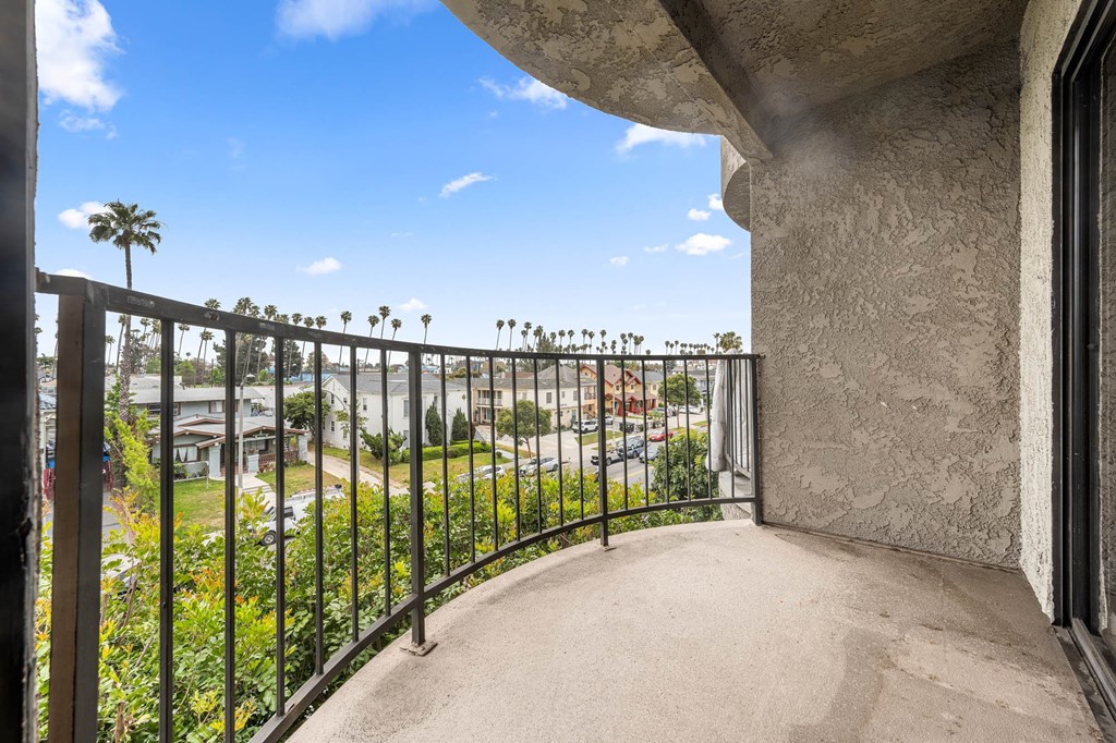 A balcony with a metal railing overlooks a residential area. at Lafayette Apartments, Los Angeles, CA