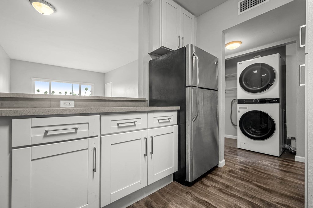 A modern kitchen with a black fridge and a washing machine at Lafayette Apartments, California, 90019