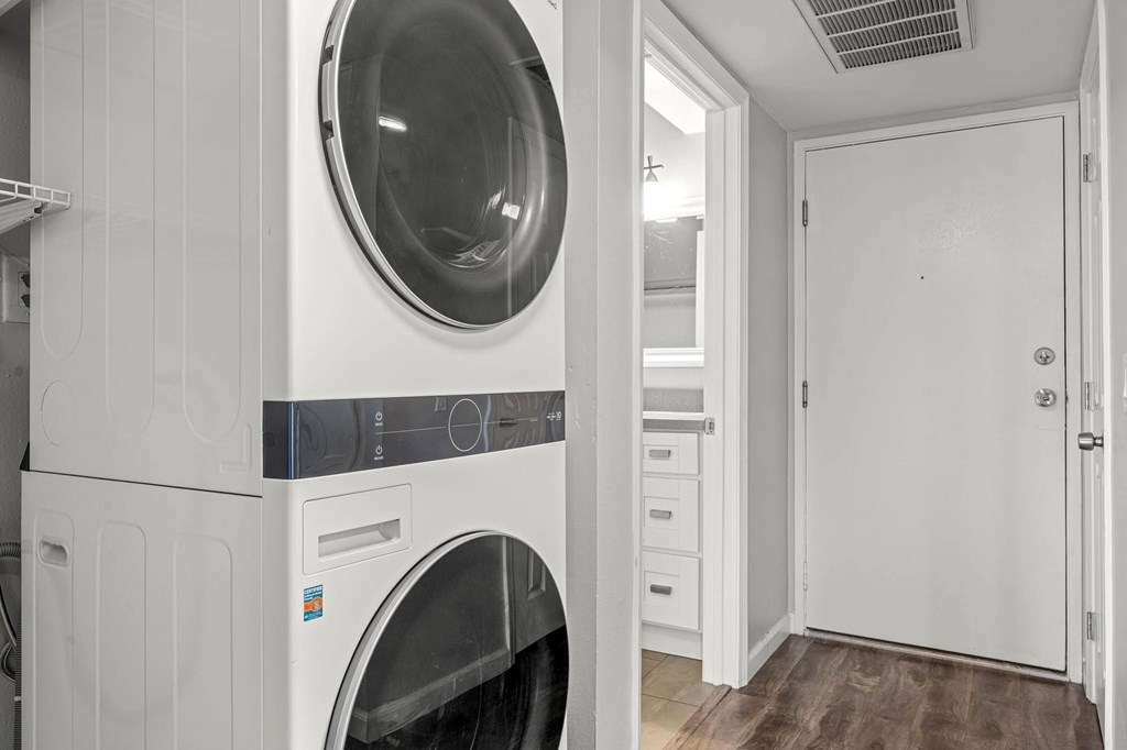 A laundry room with a washer and dryer stacked on top of each other at Lafayette Apartments, Los Angeles 90019