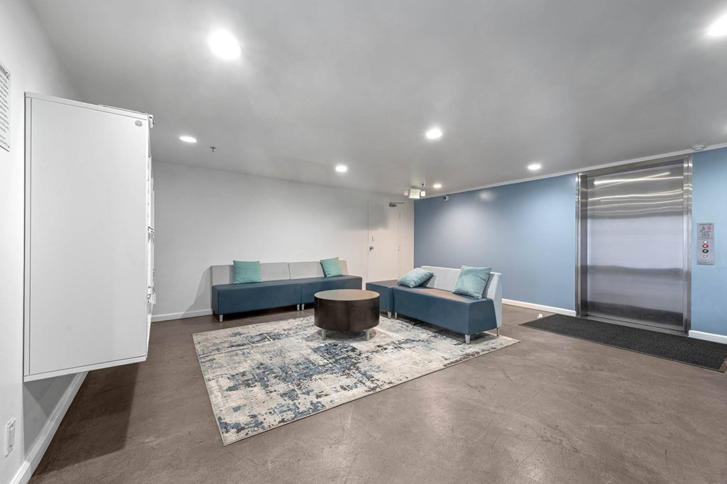 A spacious living room with a blue sofa and a coffee table at Lafayette Apartments, Los Angeles, CA