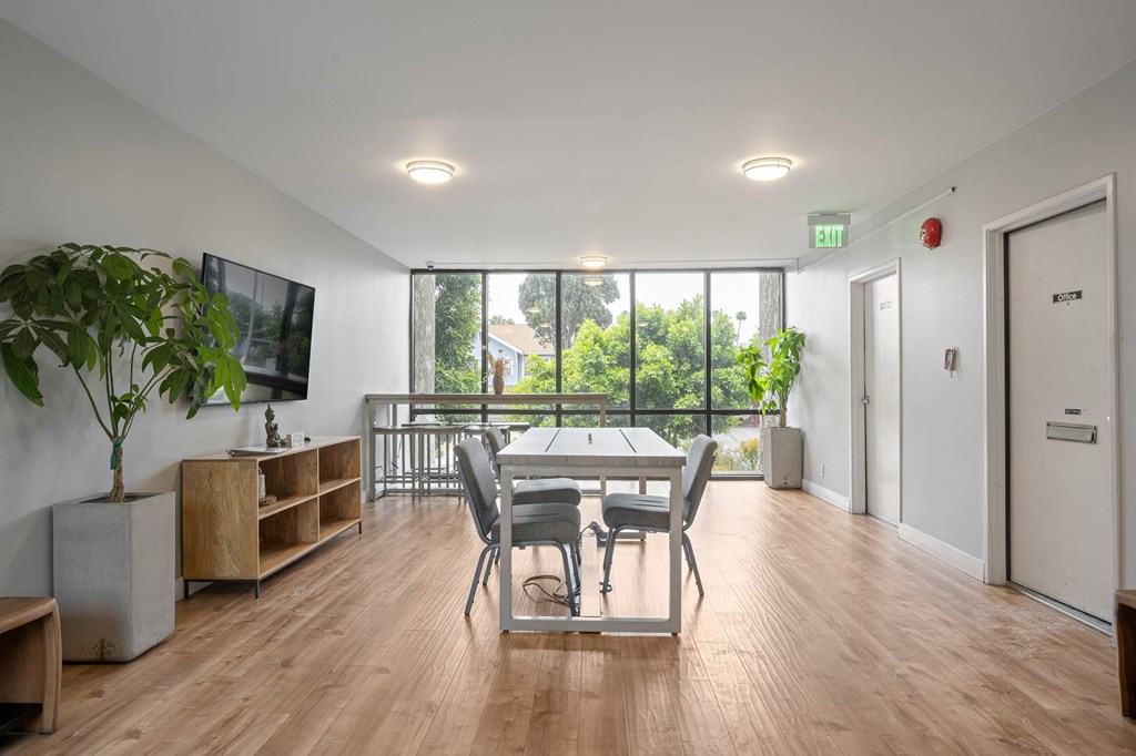 A room with a wooden floor and a large window with a view of trees at Lafayette Apartments, California, 90019